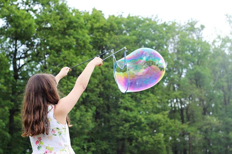 M&auml;dchen macht im Freien eine gro&szlig;e Seifenblase